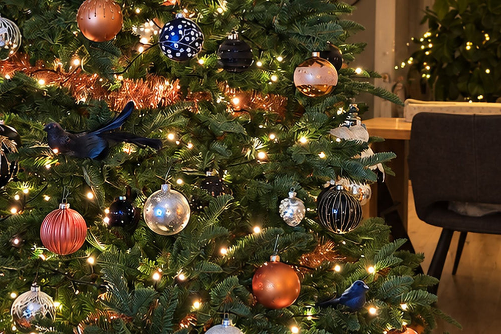 Opgetuigde kerstboom met koperen en blauwe kerstballen en warme lampjes